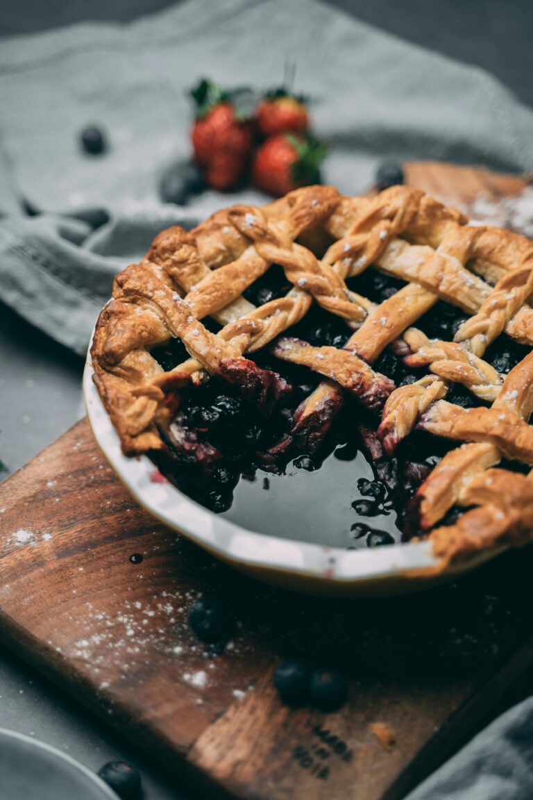 A delicious homemade berry pie with a lattice crust on a wooden board, captured in rustic style.